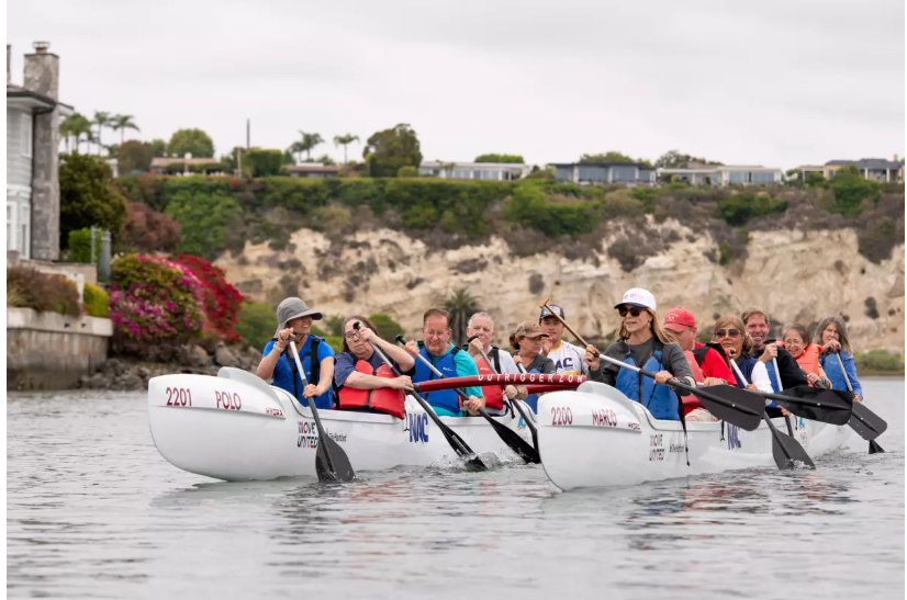 Adults with developmental disabilities as well as staff and volunteers with Project Independence and Makapo Aquatics paddle outrigger canoes in Upper Newport Bay on Friday. (Eric Licas)